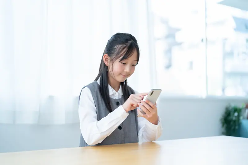 スマートフォンを操作する子ども