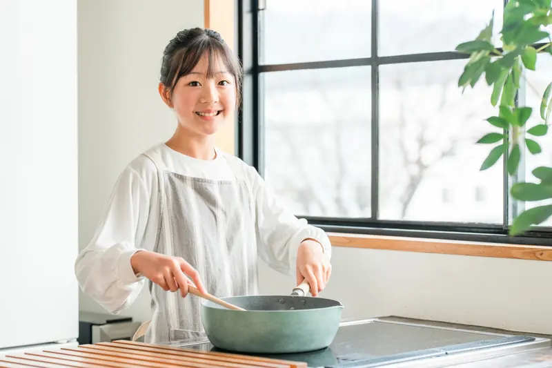 キッチンで料理をする子ども