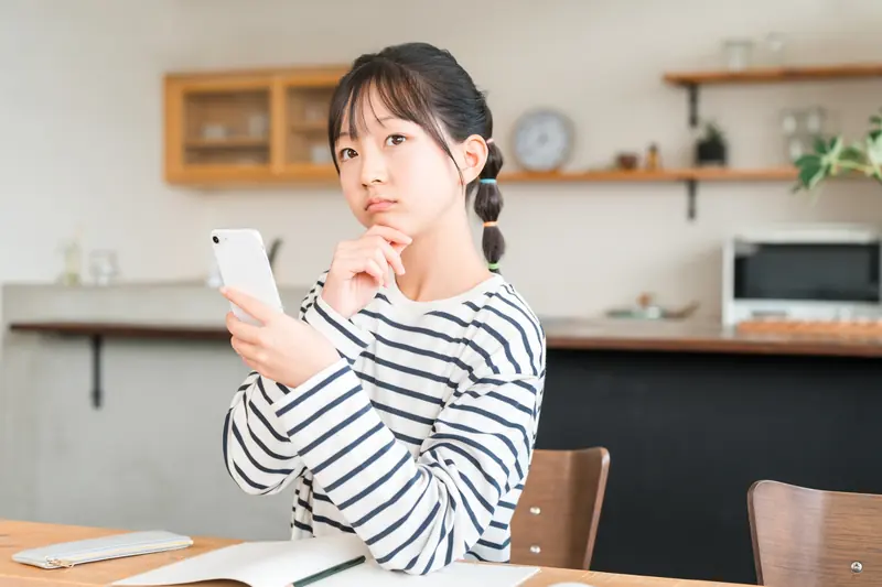 スマートフォンを手に考える子ども