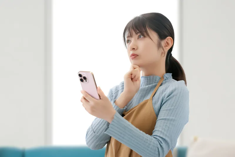 スマートフォンを手に考える保護者